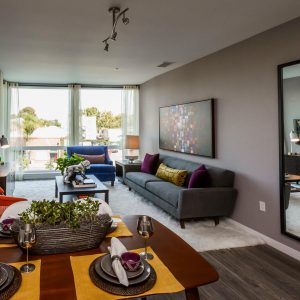 Apartments in Downtown San Jose, CA, for Rent - The Pierce - Living Room with Hardwood-Style Flooring, Plush Area Rug, Couch, Armchair, Coffee Table, and Floor-to-Ceiling Windows.